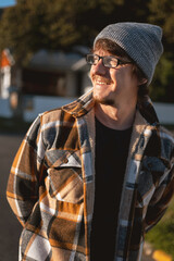 Happy Man in Plaid warm Shirt, Beanie and Glasses in Suburban Setting