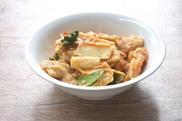 spicy fried slice fresh coconut shoot with grouper fish ball in curry on bowl