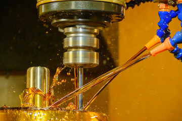 Close up scene the CNC milling machine finishing cut the brass shell mold parts with oil coolant...