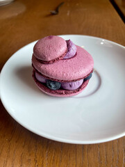 Purple berry macaron dessert with meringue on white plate. Elegant minimalistic presentation of...