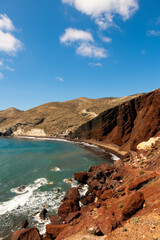 Red beach in Santorini island, Greece. Red volcanic cliffs and the blue sea.