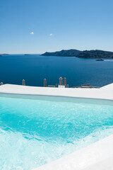 White architecture in Santorini island, Greece. Swimming pool with sea view.