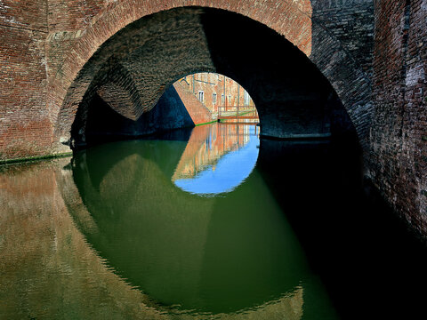old stone bridge over river in comacchio italy