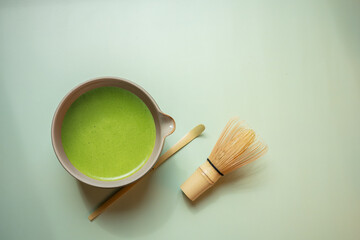 The Matcha green tea on a pastel green background, shot in still life style.