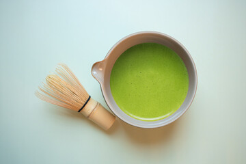 The Matcha green tea on a pastel green background, shot in still life style.