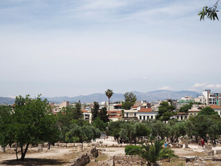 Mediterranean neighborhood scene in Athens, Greece, with traditional houses, a tall palm tree, and...
