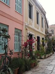 Traditional street in Plaka, Athens, with vivid house facades and potted plants creating a colorful and inviting Mediterranean ambiance.