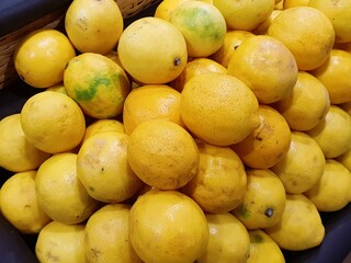 A close-up shot of a pile of fresh, yellow lemons in a basket.  The lemons are ripe and juicy, perfect for adding a zesty flavor to your favorite dishes.