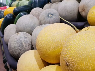 Ripe cantaloupes and honeydew melons at a market.  A vibrant display of various melons, showcasing...