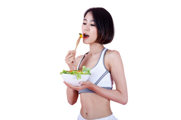 Fit Asian woman eating fresh vegetable salad with a wooden fork. Concept of healthy lifestyle, diet, and nutrition on pink background.