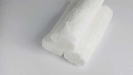 Fototapeta premium Close-up shot of three rolled gauze bandages on a white background. Ideal for medical, healthcare, or first aid concepts.