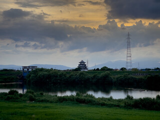 Sunomata castle a japanese castle near a river under cloudy skies.