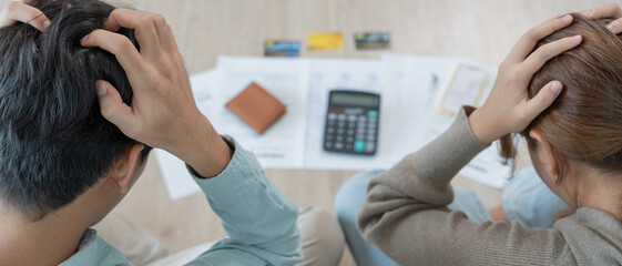 Stressed and headache asian couple with large bills or invoices no money to pay to expenses and credit card debt. shortage, Financial problems, mortgage, loan, bankruptcy, bankrupt, poor, empty wallet