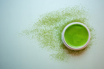 The Matcha green tea on a pastel green background, shot in still life style.