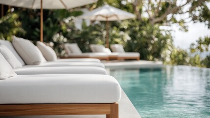 A peaceful image of white loungers by a tranquil pool, surrounded by lush greenery and umbrellas, evoking relaxation and escape from daily life.
