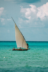 Wooden sailing boat, traditional African sailboat in Zanzibar, Tanzania on a beach with blue water