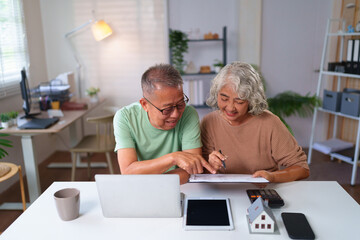 Obraz premium Asian Older Couple Planning Retirement Finances At Home Using Calculator Laptop And Tablet Happy Senior People Managing Budget Saving Money For Future