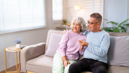 Affectionate Asian Older Couple Enjoying Retirement in Home Living Room Asian Senior Husband Wife Embrace on Sofa Happy Moment Relationship