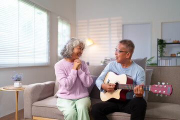 Asian Elderly Couple Enjoying Music at Home Asian Man Playing Guitar for his Partner Senior Couple Relaxing Together at Home Elderly People Lifestyle
