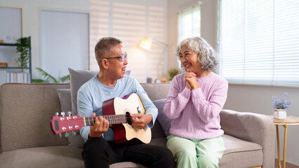 Elderly Asian Couple Enjoying Music at Home Loving Senior Man Playing Guitar for Wife Joyful...