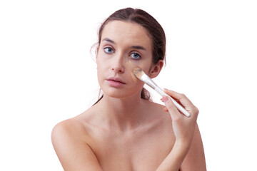 Young woman with natural skin applying foundation with a makeup brush, visible streak on cheek....