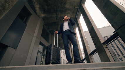Stressed middle aged business man arrive new city with baggage suitcase luggage talking mobile...