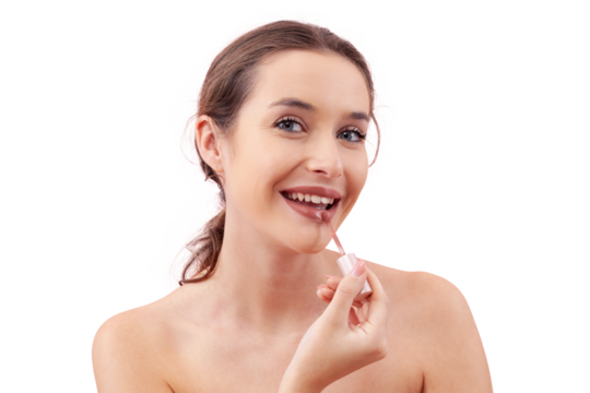 Smiling young woman applying lipstick on her lips with a lip brush applicator as part of her makeup routine. Smooth, flawless complexion. Beauty concept, isolated on white, looking into camera