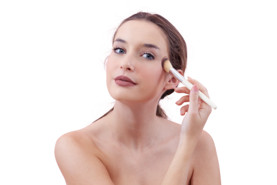 Portrait of a smiling young woman applying blush with a makeup brush while looking into the camera with her blue eyes. Clean, minimal beauty routine concept. Isolated on white background.