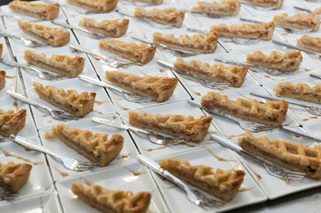 Apple pie portions on small white ceramic plates prior to serving dessert at a wedding banquet.