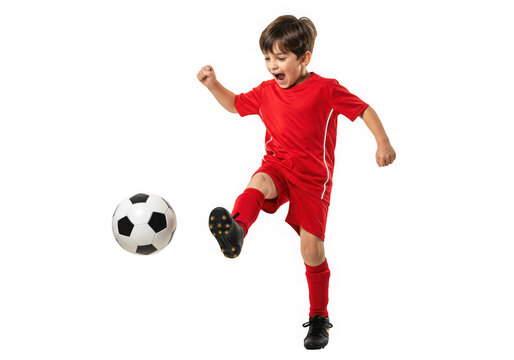 Excited young boy in red sports uniform dynamically kicking a soccer ball with energy and focus.