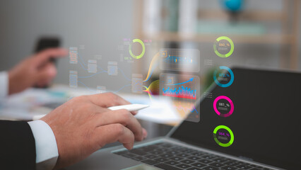 Business professional analyzing holographic data visualizations, charts, and metrics above a laptop. Business intelligence, financial analysis, digital reporting.Finance and technology concepts.
