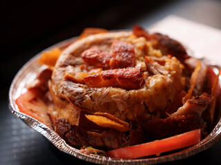 Close-up of a savory mofongo takeout plate, golden plantains mashed with garlic and chicharron