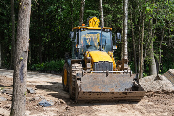 yellow wheel loader parked on forest trail renovation site