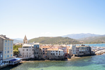 This coastal town features stunning views of the sea and hills under a clear blue sky, captivating...