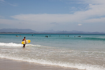 Man walking with yellow surfboard