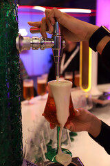 barman llenando una copa de cerveza con espuma desde el grifo de barril en la barra
