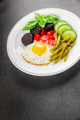 English breakfast fried egg, black pudding, vegetables, beans fresh delicious gourmet food...