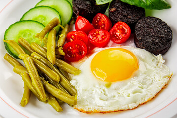 English breakfast fried egg, black pudding, vegetables, beans fresh delicious gourmet food background on the table rustic food top view copy space