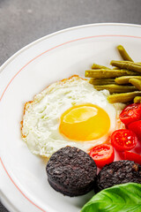 English breakfast fried egg, black pudding, vegetables, beans fresh delicious gourmet food...
