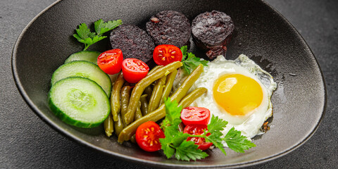 English breakfast fried egg, black pudding, vegetables, beans fresh delicious gourmet food...