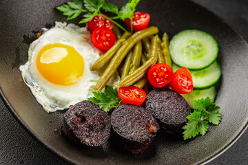 English breakfast fried egg, black pudding, vegetables, beans fresh delicious gourmet food background on the table rustic food top view copy space
