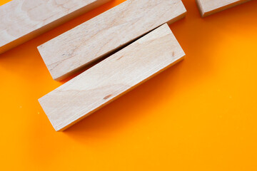 Several wooden blocks lie on a bright orange background, creating a minimalist composition. This...