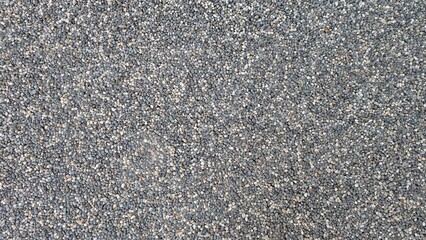 Close-up of grey small pebbles gound surface texture