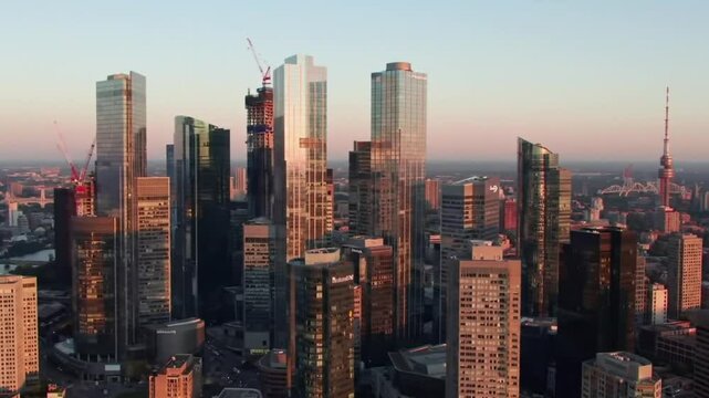 Aerial sunset view of Torontos downtown skyscrapers under construction, perfect for urban development websites, construction companies, and cityscape presentations. Suitable for commercial use.