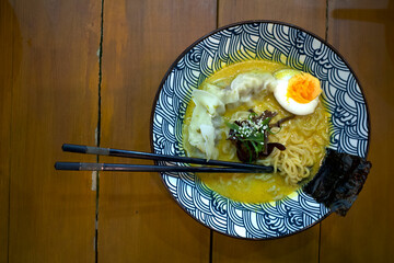 A bowl of ramen noodle, Japanese food with chopstick on a wooden table