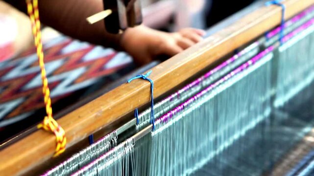 Making tenun ikat Bandar, Indonesia. An Indonesian woman weaving traditional fabric. Traditional weaving cotton in Indonesia.