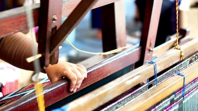 Making tenun ikat Bandar, Indonesia. An Indonesian woman weaving traditional fabric. Traditional weaving cotton in Indonesia.