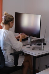 Woman Drinking Juice and Working on Laptop at Home