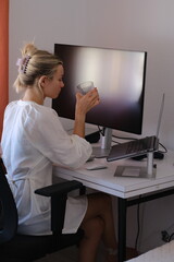 Woman Drinking Juice and Working on Laptop at Home