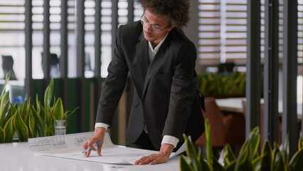 African American businessman business man professional engineer architect working in office holding paper blueprint building plan entrepreneur male put sketch on table analyze city development design